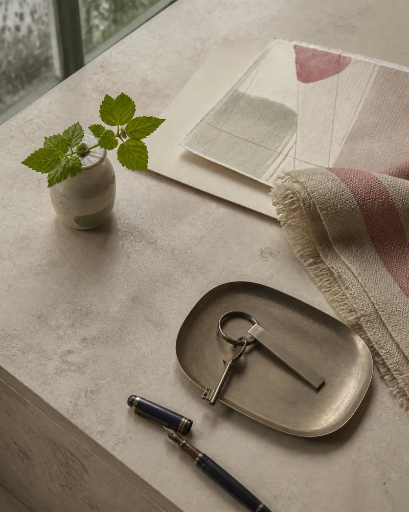 Conciërgetafel met textiel, pen, plant en een onbedrukte sleutel
